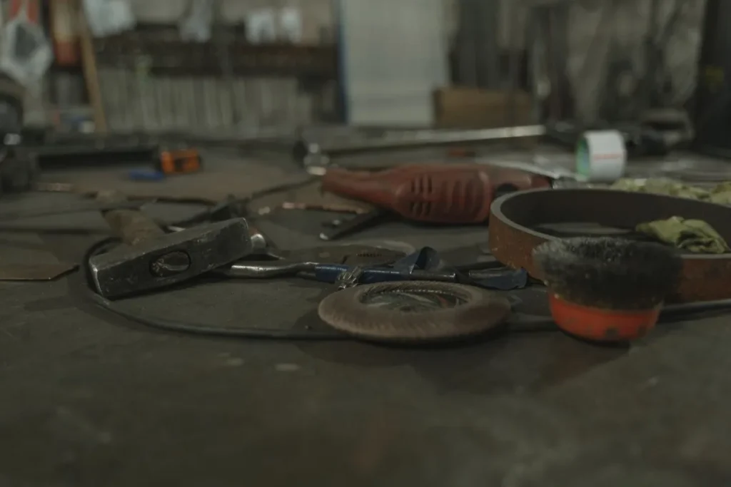 Établi d'atelier avec marteau, disque abrasif et outils de réparation, gros plan